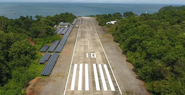 Aerial of the island airstrip lined with solar arrays